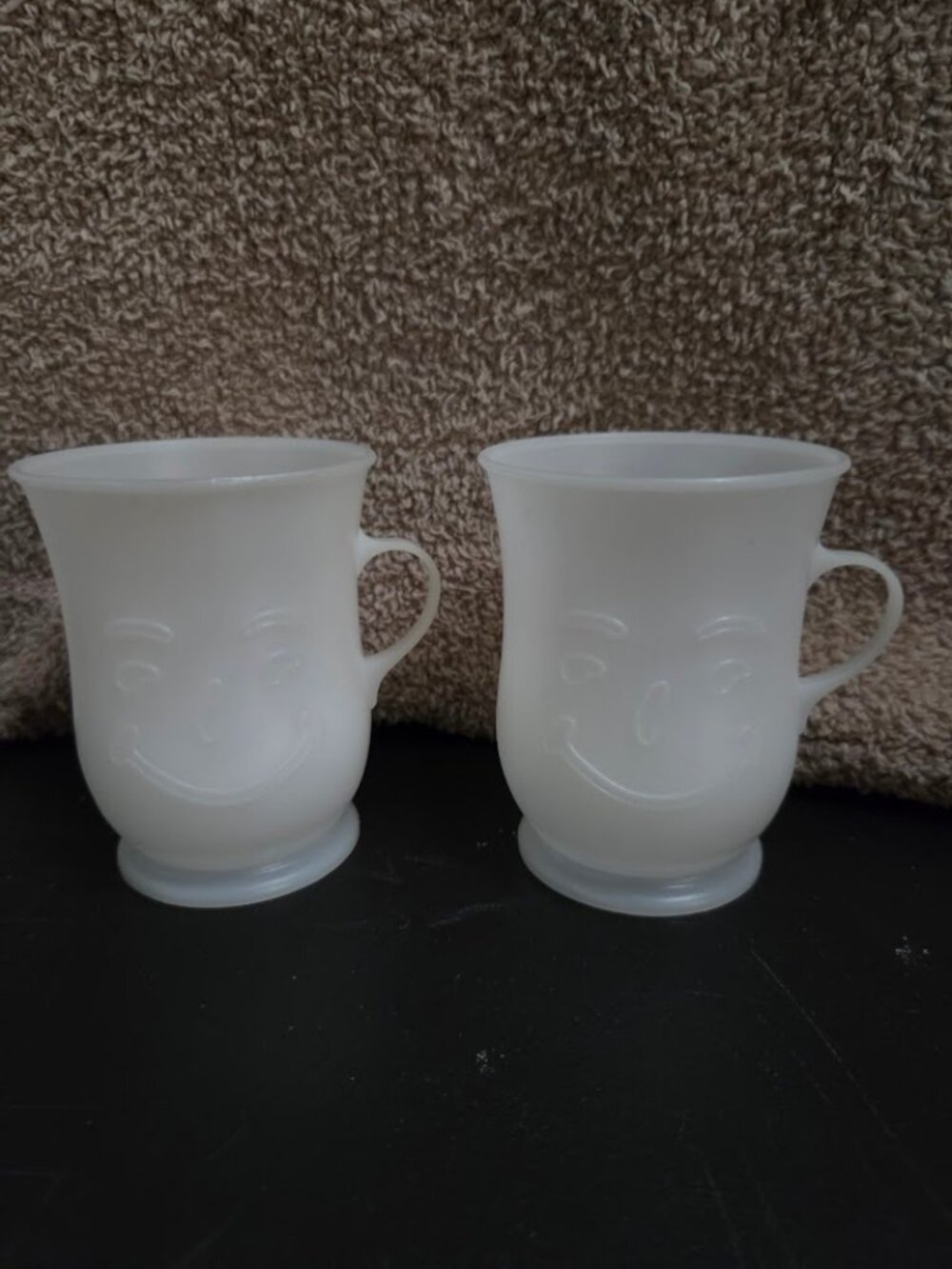 Two vintage 8 oz white plastic Kool-Aid Man smiley face mugs from the 1970s–1980